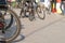 Bicycle wheel standing on the ground close up. Background of blurred images of other bikes.