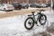 Bicycle with a wide rubber in the parking lot near the store in the city in the winter close