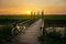 Bicycle on wooden fence of bridge at sunset