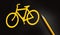 Bicycle yellow sign on black and a pencil besides. Healthy living and energy saving concept