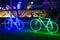 Bicycles decorated with blue and green lights shine at night