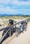 Bicycles leaning against a wooden rail on a beach boardwalk