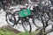 Bicycles locked on bicycle stands in the street.  Heineken box on front rack