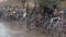 Bicycles parked against the railings with a lot of posters on it.