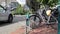 Bicycles parked at the side of a road. Car and cyclist pass on street