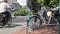 Bicycles parked at the side of a road. Cyclist rides past on street