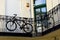 Bicycles tied to the corridor railing in old residential building inner court yard.