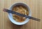 Bifum vegetable noodles in a white crockery bowl with two chopsticks on a bamboo placemat.