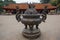 A Big antique bronze incense burner with the House of Ceremonies in the background at Temple of Literature Original built in 1070