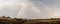 A big arching rainbow over a small countryside Suffolk village