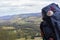 Big backpack with pilgrim shell on mountain background. Pilgrimage concept. Pilgrim on Camino de Santiago road.