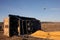 Big basket of the balloon lies on its side on the field ground a