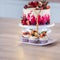 Big beautiful red velvet cake, with flowers and berries on top. Delicious sweet muffins with cream,