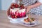 Big beautiful red velvet cake, with flowers and berries on top. Delicious sweet muffins with cream,