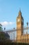 Big Ben tower in London behind fences with blue sky