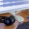 Big black headphones lie on the wooden desktop of the sound designer