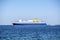 Big blue ferry boat floating on Aegean sea under a clear blue sky. Greece