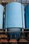 Big blue metallic Industrial silos for the production of cement at an industrial cement plant on the background of blue sky.