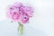 big bouquet of pink peony in transparent vaze on white background, holiday mood, greetings and congratulations with mother`s day,