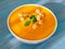 big bowl of pumpkin soup on a wooden blue background. Bright tasty dish, side view