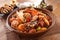 Big bowl of Spicy Seafood galbijjim with clams, shrimp, octopus, crab, potatoes, onion and mushroom on wooden korean table