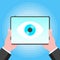 Big brother concept. Hands holding stablet pc spying with big eye on the screen isolated on light blue background