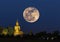 Big buddha statue in temple at night with super moon