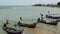 Big Buddha temple surrounded by calm water and old Muslim fishing longtail boats on seaside of Samui paradise tropical