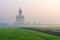 The Big Buddha at Wat Muang Temple with fog and grass