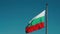 Big Bulgarian flag on pole waving in the wind on clear blue sky background. Isolated. Slow motion