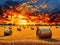 the big burning sunset over farm field with hay bales, AI generated