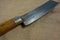 Big butcher knife on bagging fabric background. Closeup view of weapon or utensils with long blade and handle like machete,