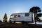 Big camper motorhome parked in off road nature space to enjoy total freedom. Off grid lifestyle vanlife. Travel with camping car