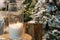 Big candles in glass vases in a snow-covered park or a forest while snowing