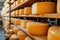 Big cheese wheels at manufacturing closeup. A cheese dairy in a warehouse with cheese