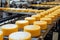 Big cheese wheels at manufacturing closeup. A cheese dairy in a warehouse with cheese