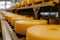 Big cheese wheels at manufacturing closeup. A cheese dairy in a warehouse with cheese