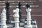 Big chess in park on chessboard. Giant pieces of white chess knight, black chess king and pawns close-up. Selective focus