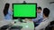 Big chromakey monitor in modern office with thoughtful multiethnic coworkers brainstorming. Group of professional