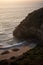 A big cliff in front of the sea and a green coast, during a beautiful sunset in Quirilluca beach