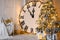 Big Clock Shows 12 o`clock. Christmas Tree with Golden Lights. White Molding on Wall