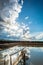 Big clouds with starburst sun and reflections in water