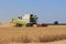 A big combine harvester is harvesting wheat in the dutch countryside in holland
