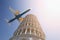 Big commercial passenger airplane flying over leaning tower of Pisa in Italy on bright sunny day. Visit Italy concept. Travel to