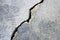 Big crack on old plastering wall. Long winding ascending crack in cement surface of an old building. Copy space