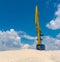 Big crane, blue sky and hills of river sand