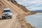 Big crossroad 4WD car is approaching major campsite in colorful rainbow volcanic Landmannalaugar mountains with thousands tourists