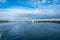 Big cruise ship moving along the coast at sunny summer day. Forest islands of Scandinavia. Beautiful clouds. Panoramic View of