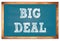 BIG DEAL words on blue wooden frame school blackboard