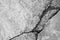 Big deep branched crack on gray wall, abstract image of diagonal cleft. Close-up. Horizontal photo. Black and white photo.
